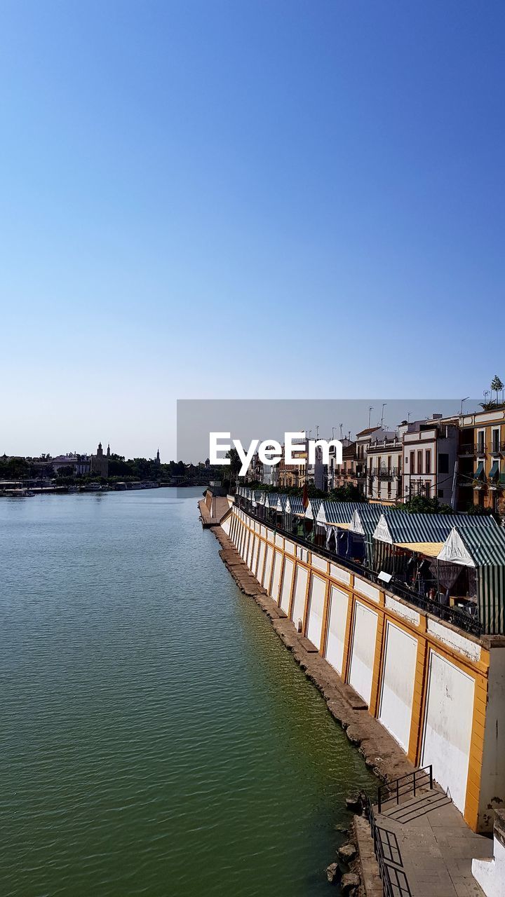 Scenic view of river against clear blue sky