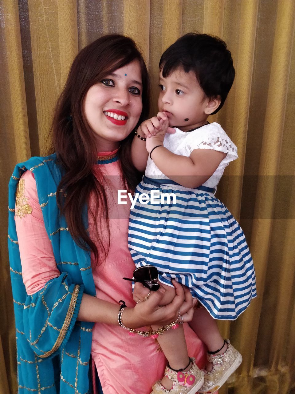 Portrait of smiling aunt and niece at home