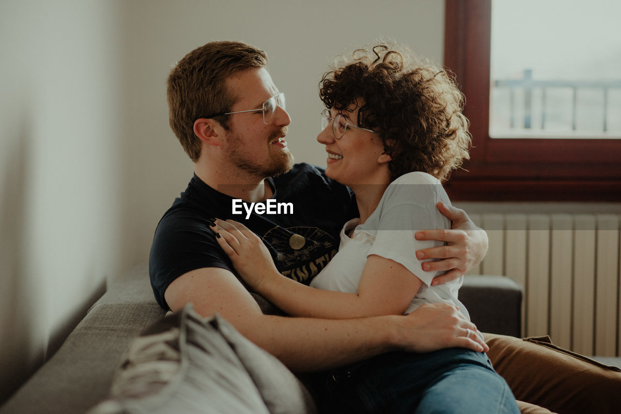 MIDSECTION OF COUPLE SITTING AT PARK