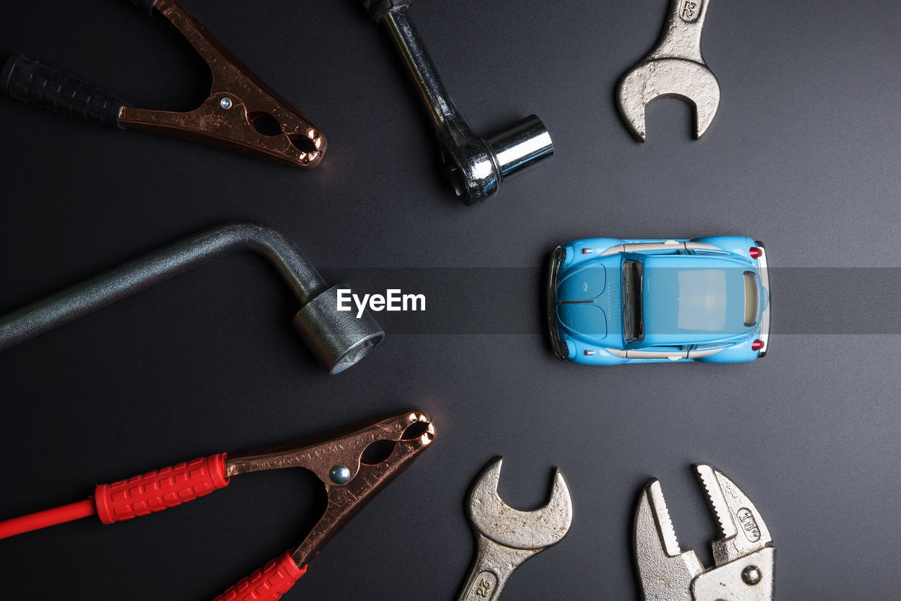 Directly above view of hand tools with toy car on gray background