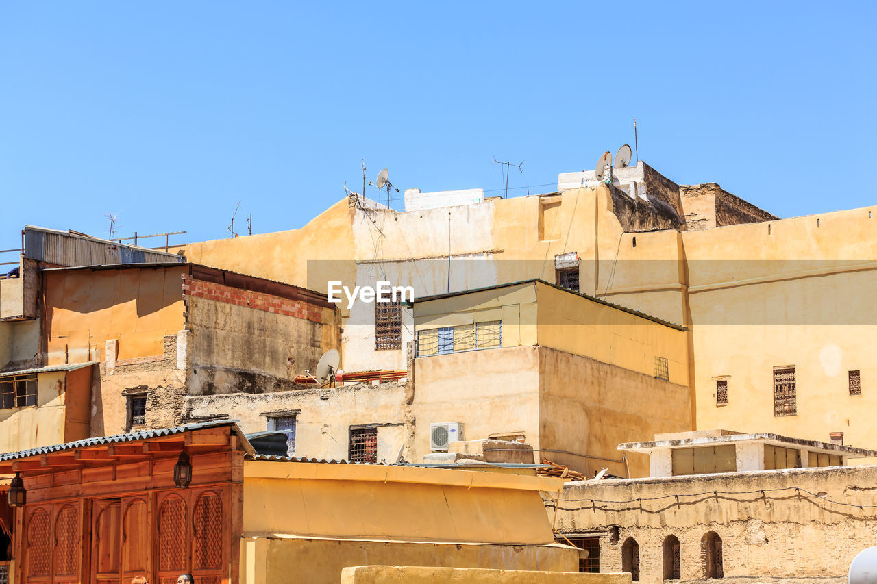 Low angle view of buildings against clear blue sky