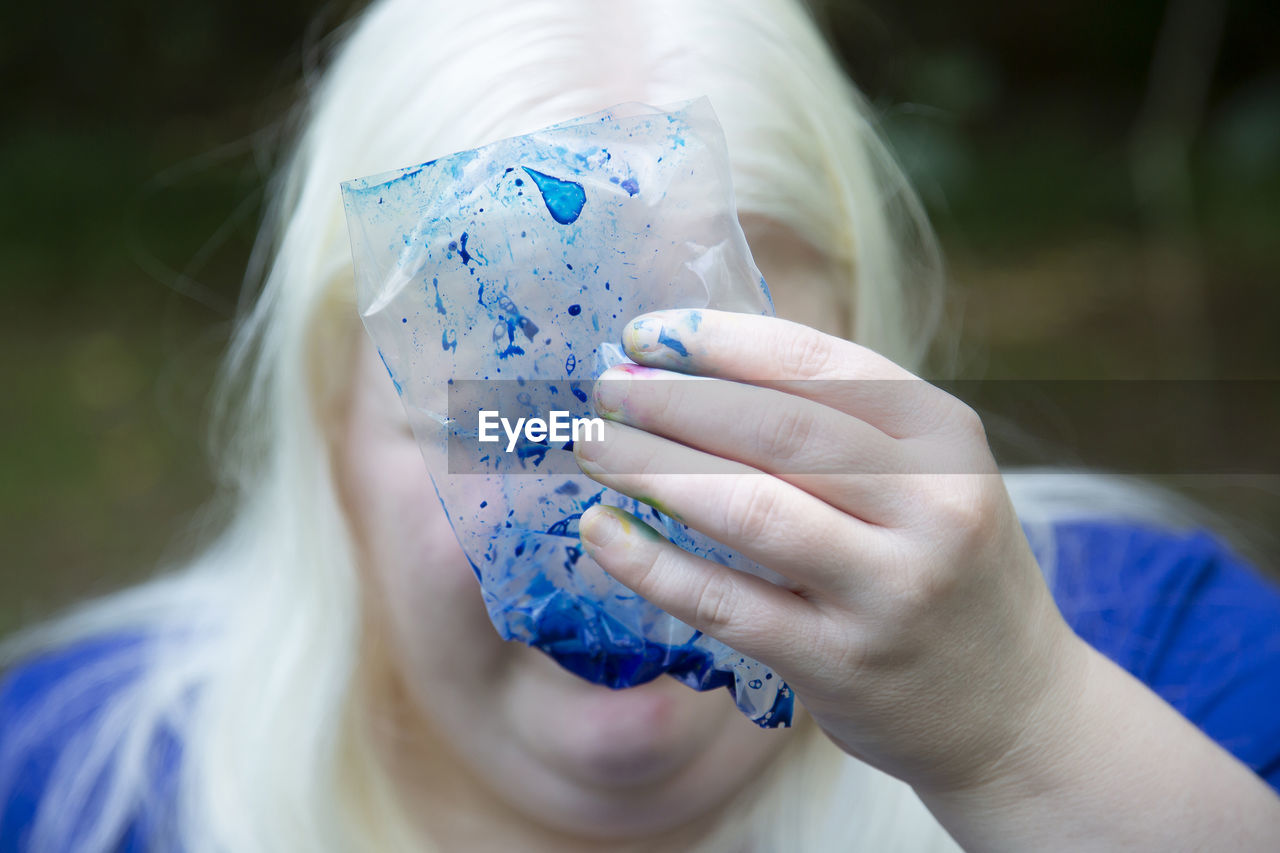 CLOSE-UP PORTRAIT OF WOMAN HOLDING GIRL WITH BLUE EYES