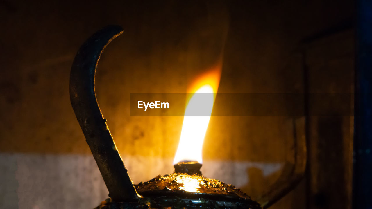 Close-up of lit oil lamp at home