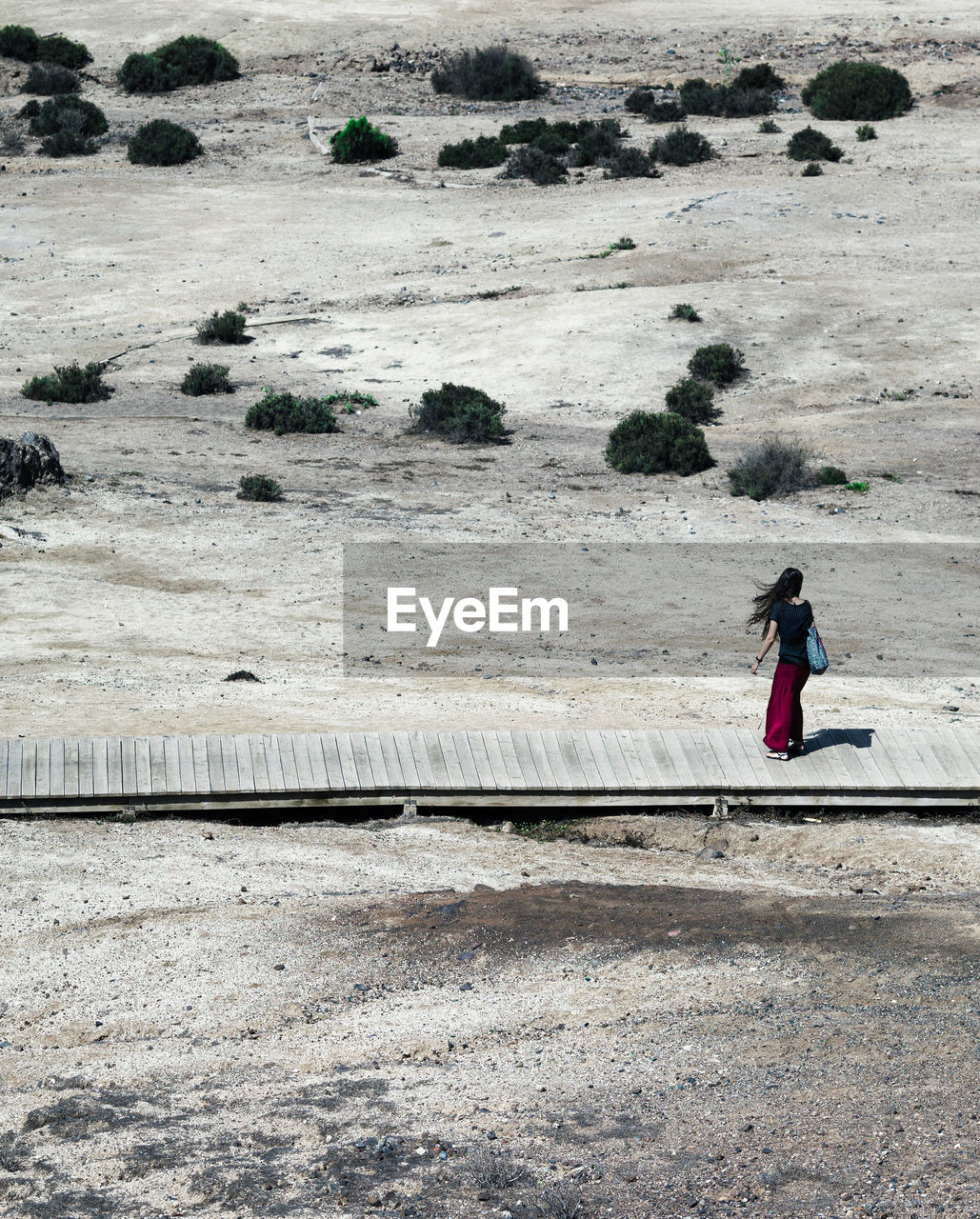 High angle view of woman standing on boardwalk at desert