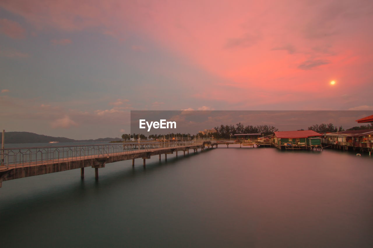 Bridge over river against sky during sunset