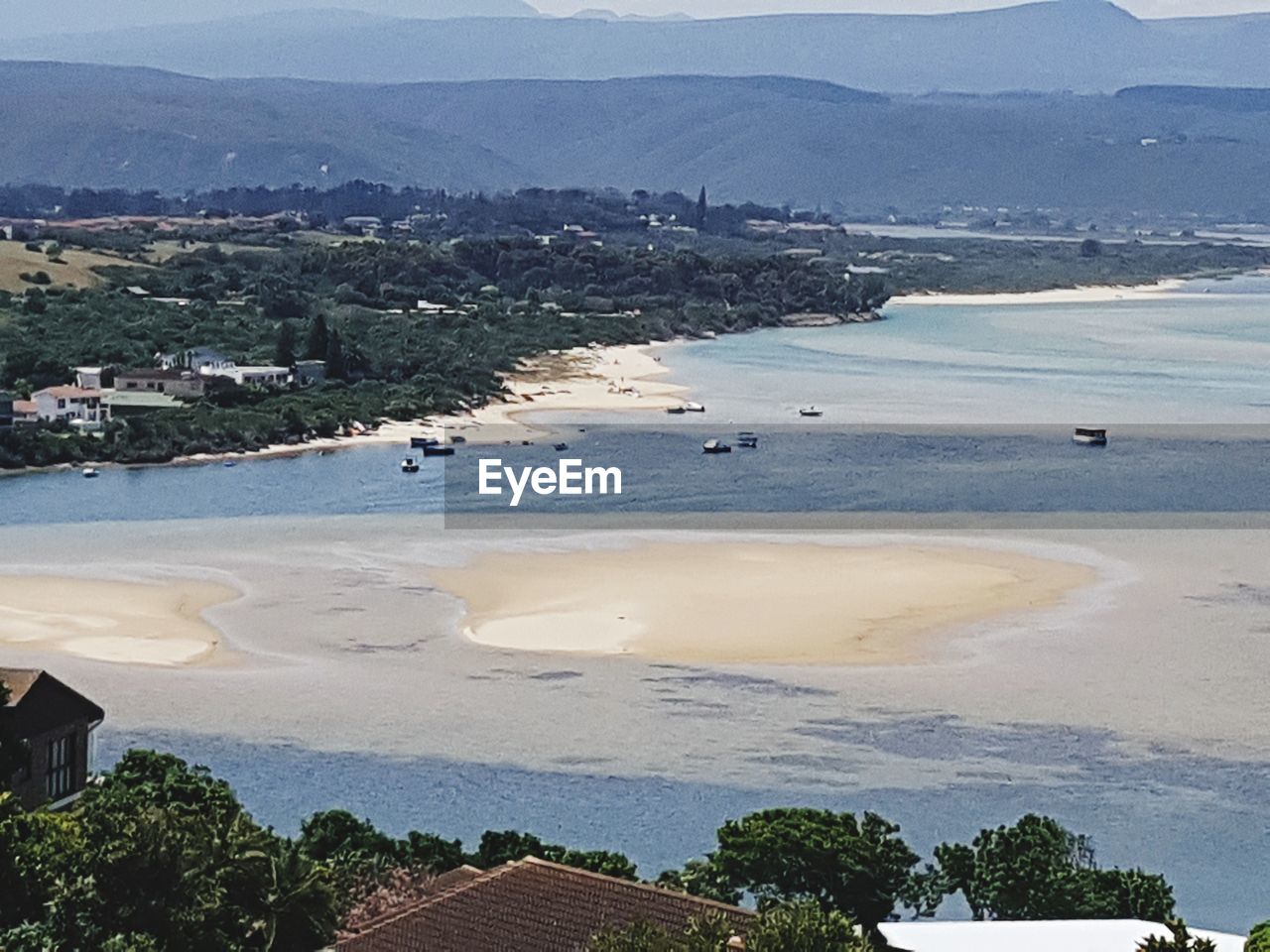 HIGH ANGLE VIEW OF BEACH BY MOUNTAINS AGAINST SKY