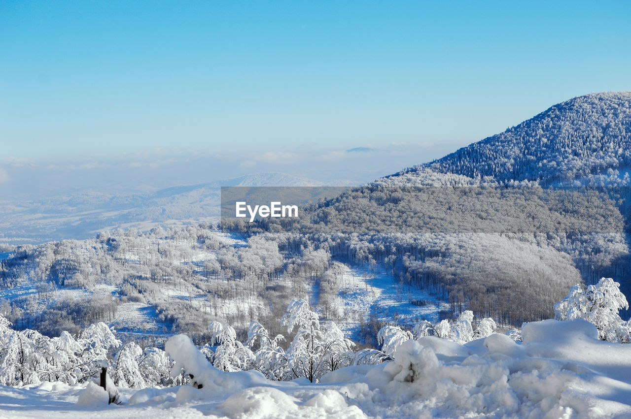 SNOW COVERED LANDSCAPE AGAINST SKY