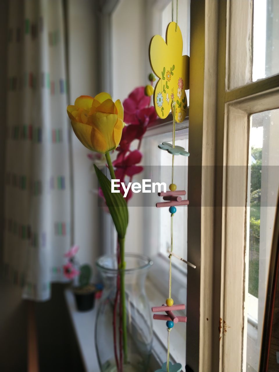 CLOSE-UP OF FLOWER VASE ON WINDOW SILL