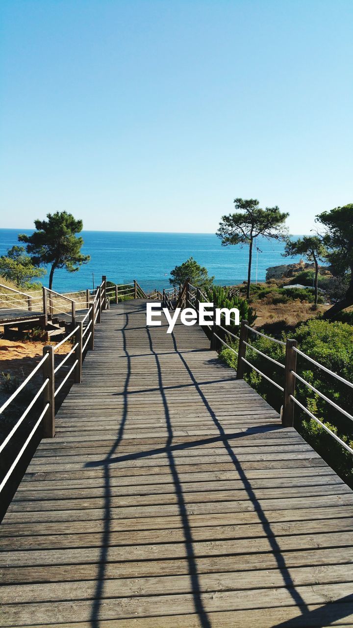 WALKWAY BY SEA AGAINST CLEAR SKY