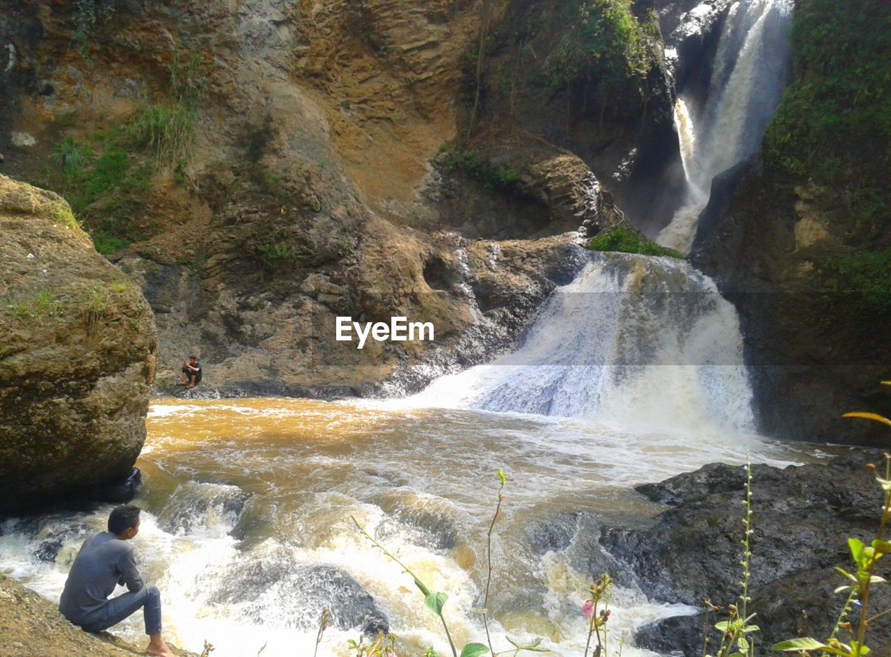 SCENIC VIEW OF RIVER FLOWING THROUGH ROCKS IN FOREST