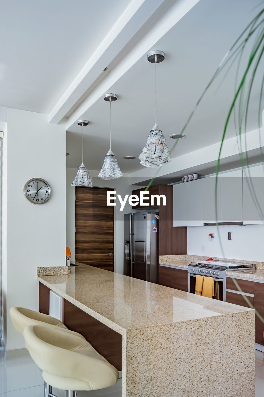 Modern wooden kitchen, with black or gray granite bar, with tile backsplash, light floor.