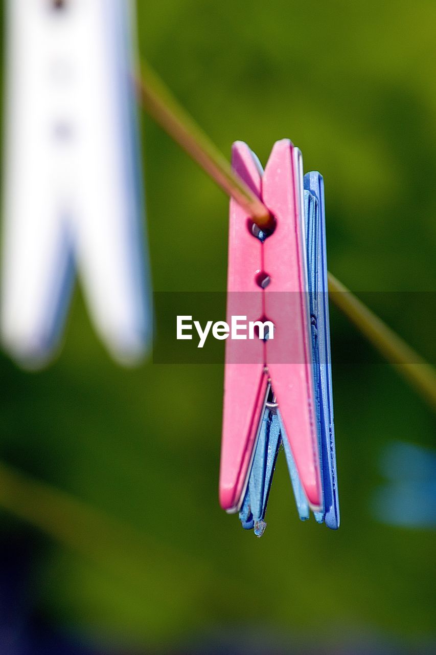 Low angle view of clothespins on metal rod