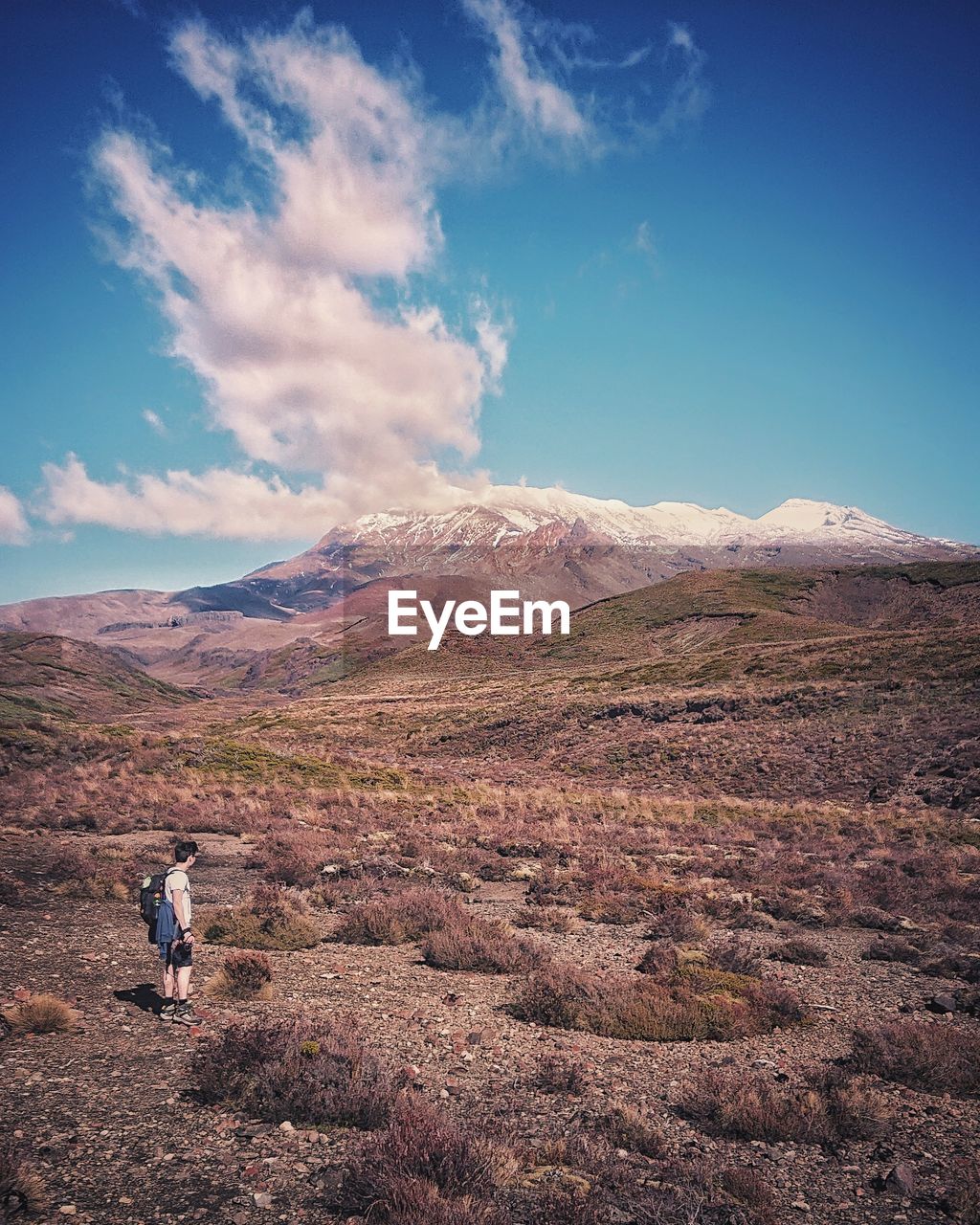 Scenic view of a volcanic landscape against a blue sky with a few clouds. 