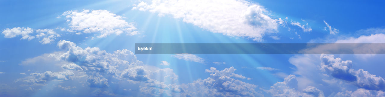 Blue sky with white clouds and sunbeams