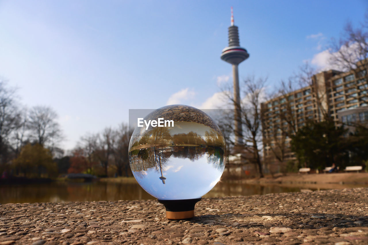 Close-up of crystal ball against sky