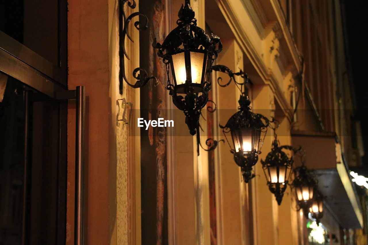 Low angle view of illuminated chandelier hanging on ceiling