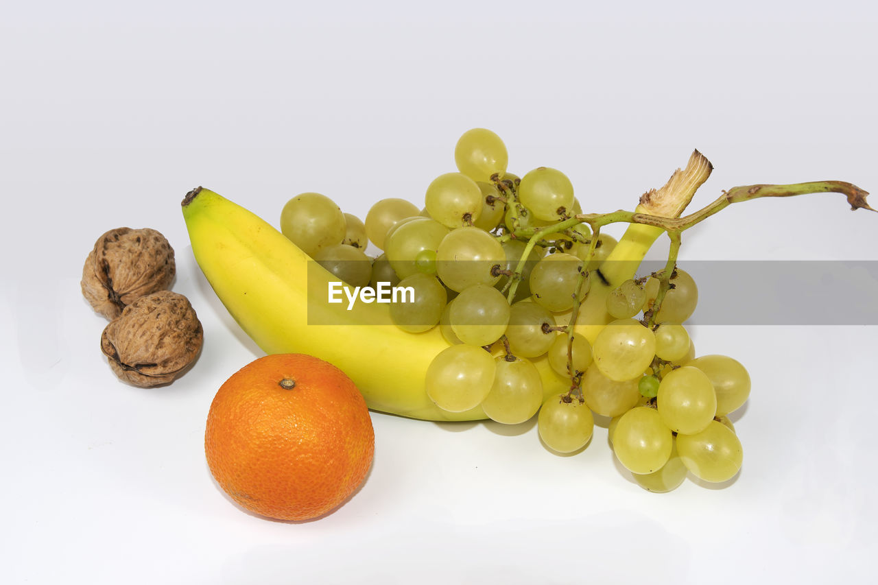 CLOSE-UP OF FRUITS OVER WHITE BACKGROUND