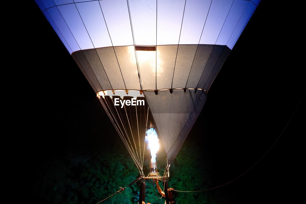 low angle view of illuminated light against sky at night