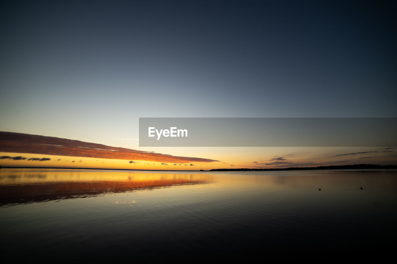 Scenic view of lake against sky during sunset
