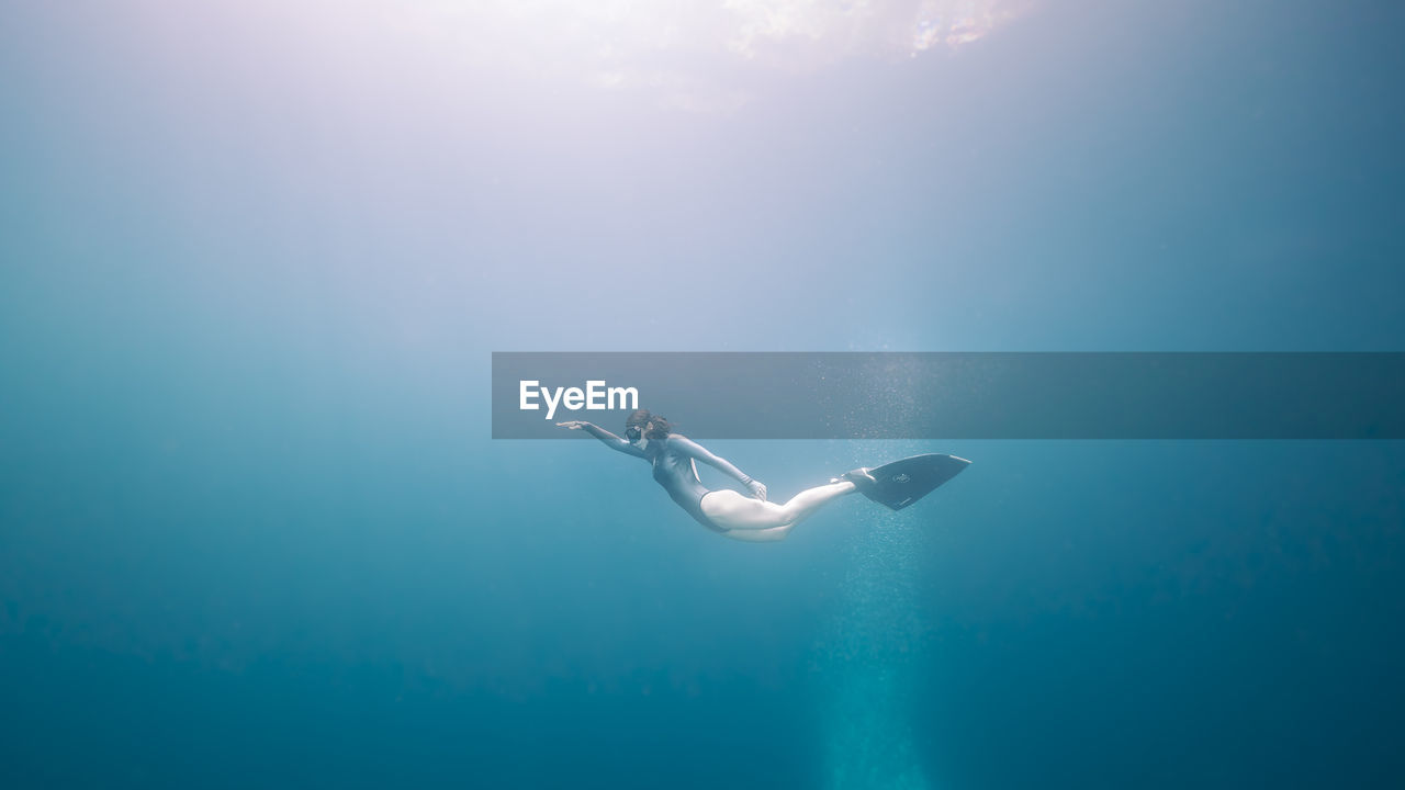 Low angle view of woman swimming underwater