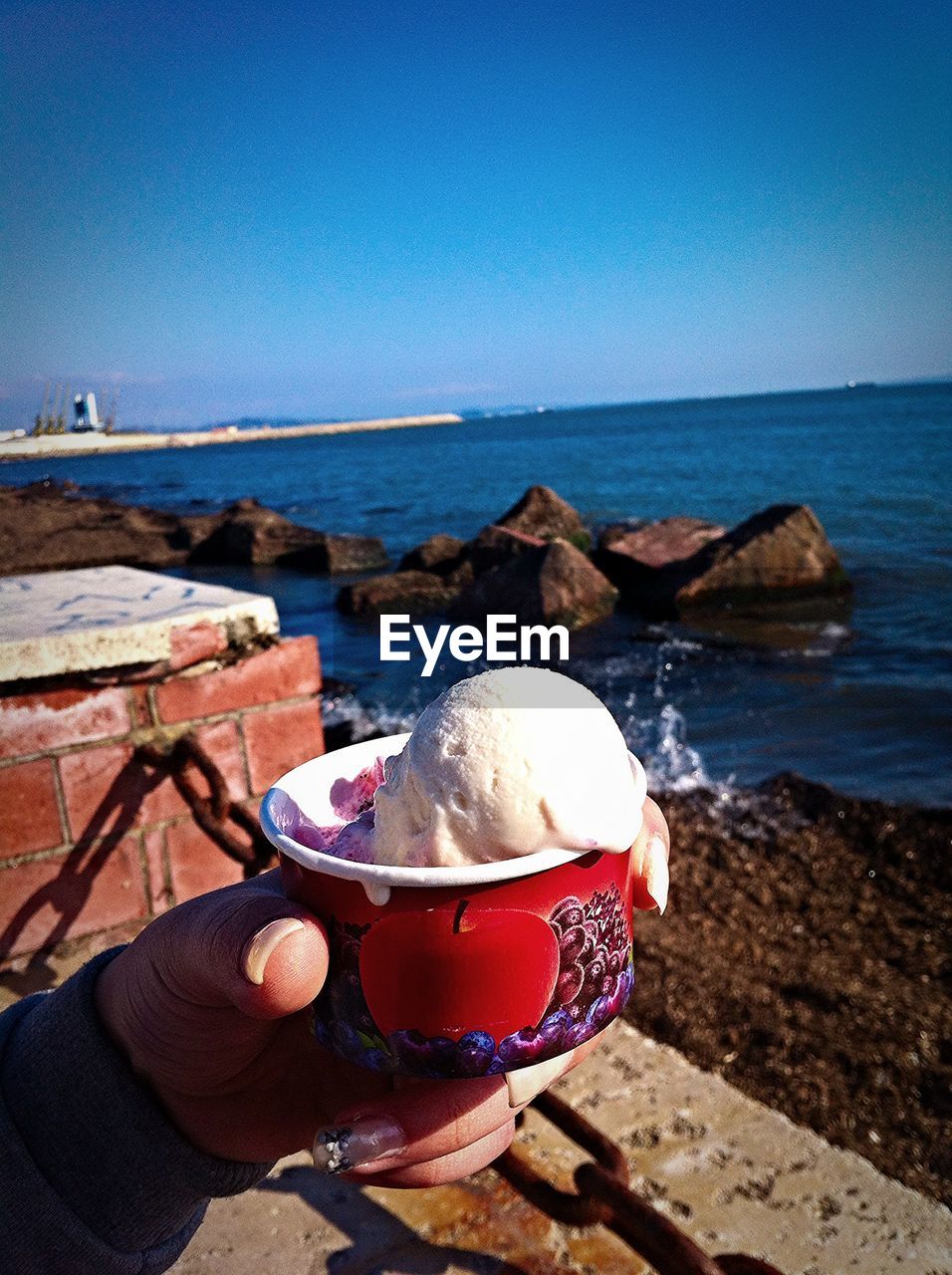 Close-up of woman hand holding cup of ice cream