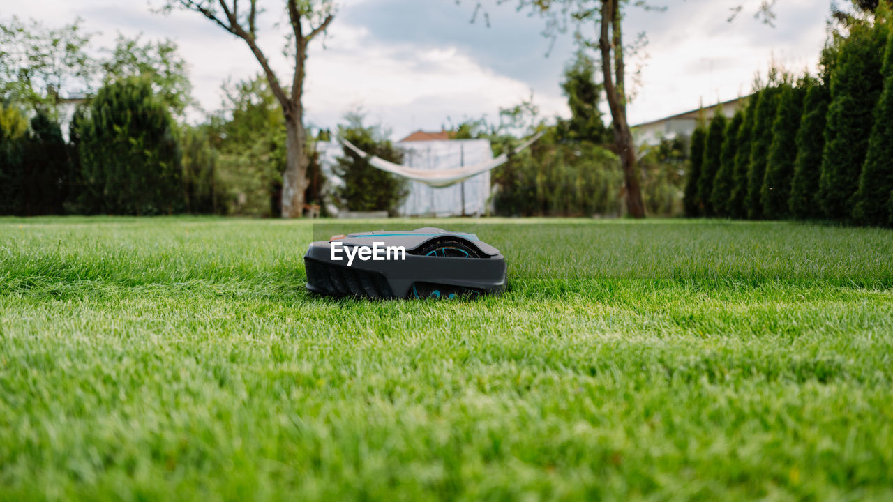 Automatic lawn mower at garden. banner photo