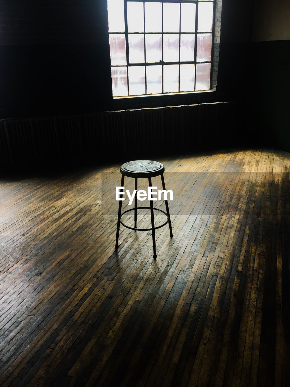 Empty chairs and table against window