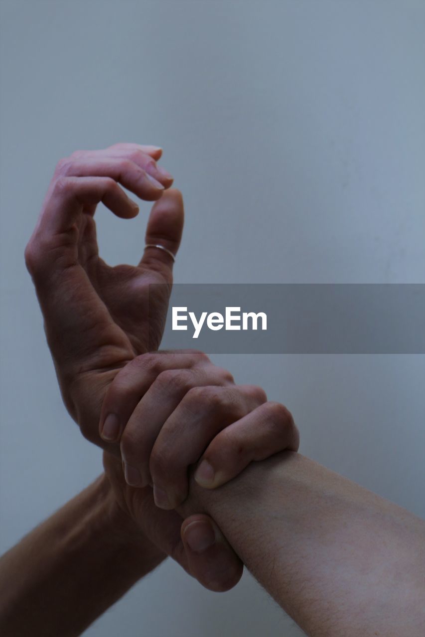 Close-up of hands against white background