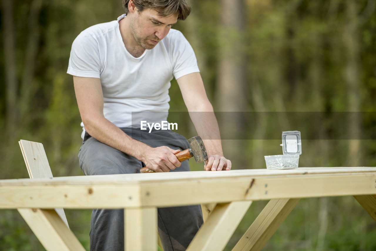 MAN HOLDING UMBRELLA ON TABLE