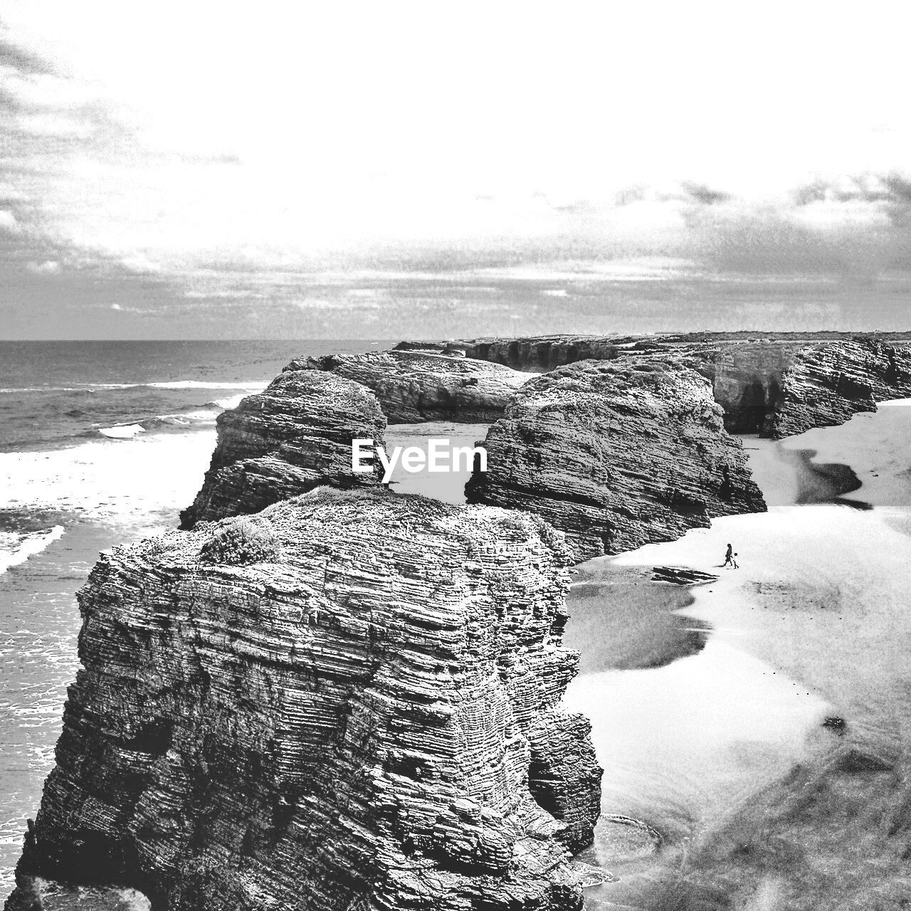 Seaside rocks with people walking