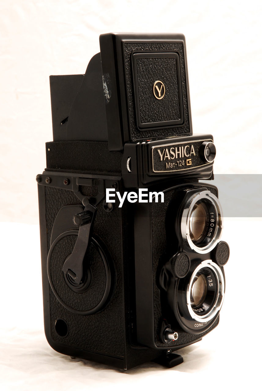 CLOSE-UP OF VINTAGE CAMERA ON WHITE BACKGROUND