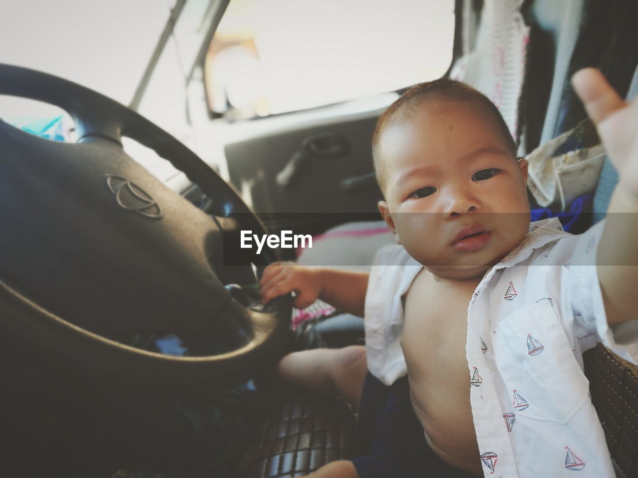 CLOSE-UP PORTRAIT OF CUTE BABY GIRL IN CAR