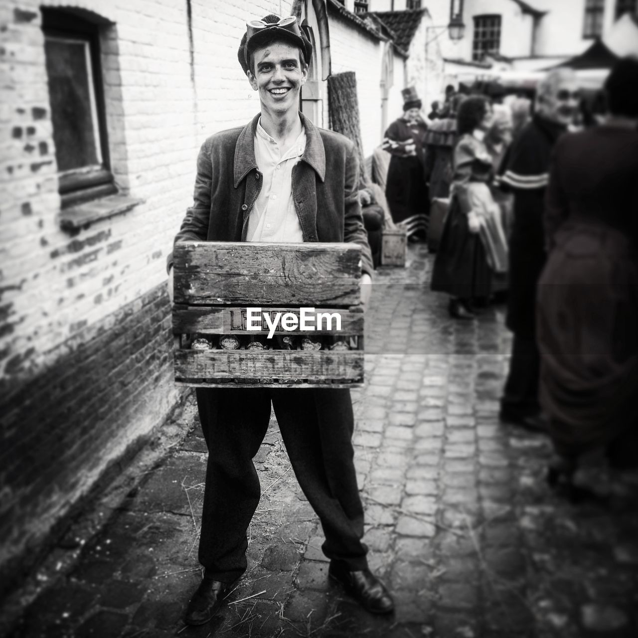 Portrait of smiling steampunk carrying crate