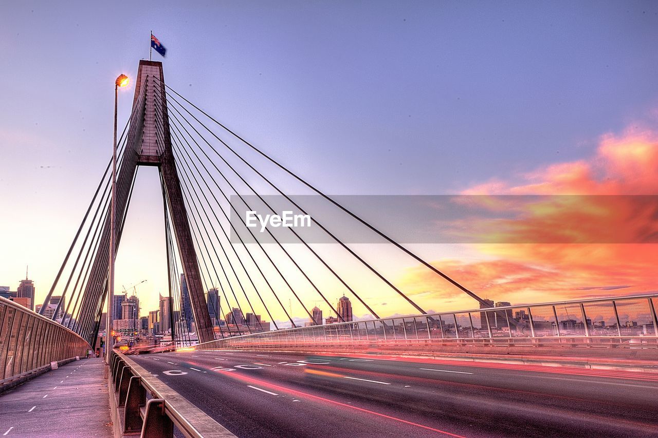 Light trails on anzac bridge against sky during sunset