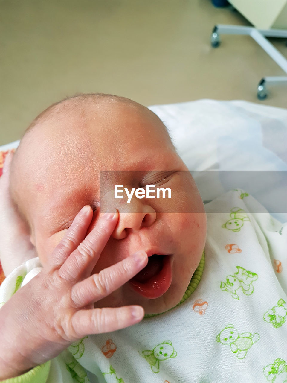 Close-up of baby girl on bed at hospital