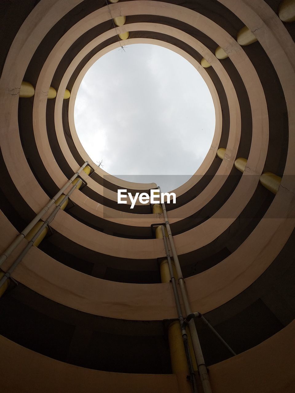 LOW ANGLE VIEW OF SPIRAL STAIRCASE AGAINST SKY