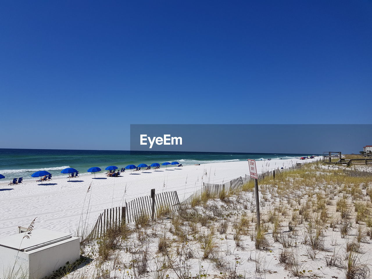 Scenic view of beach against clear blue sky