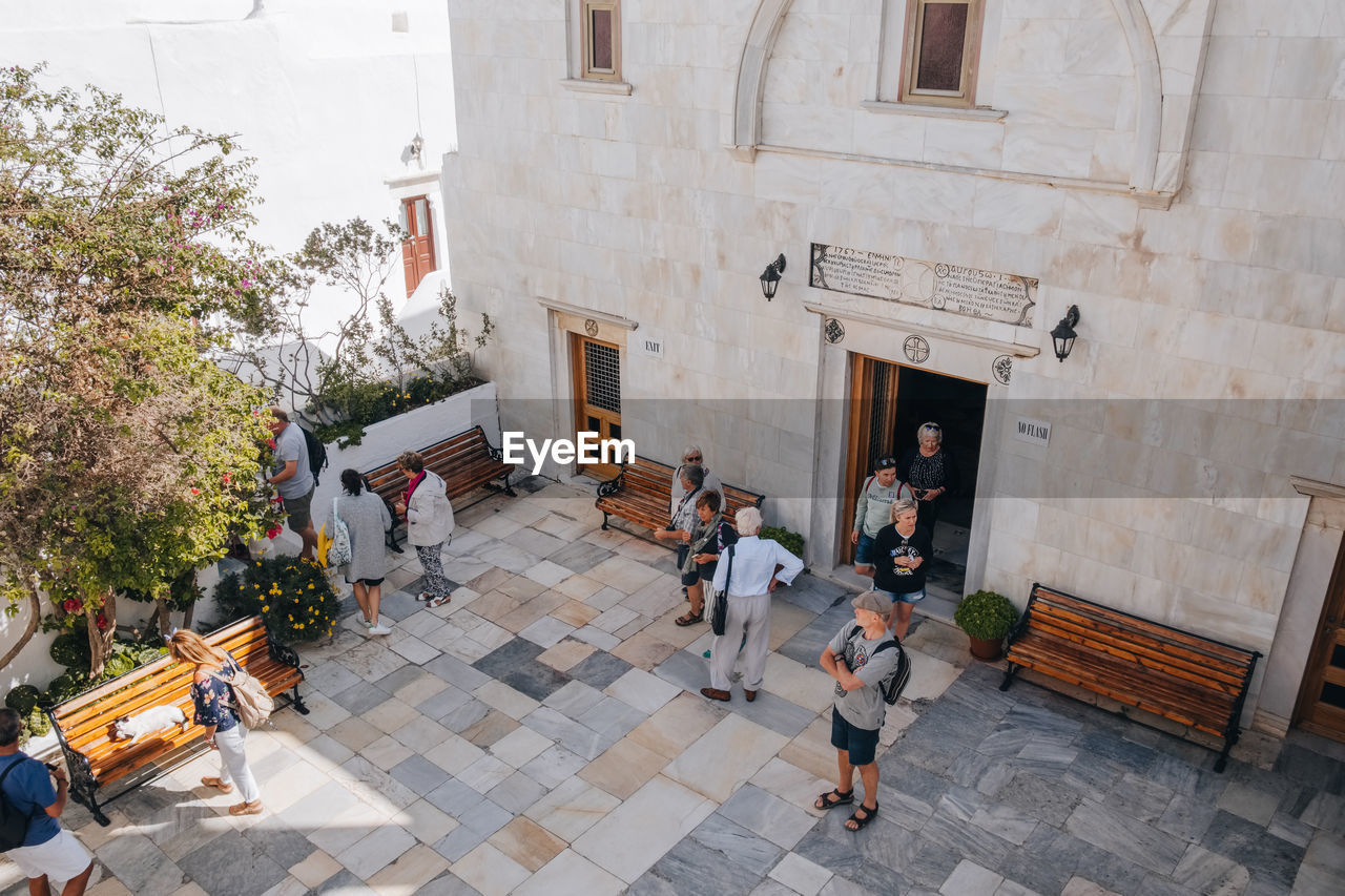 HIGH ANGLE VIEW OF PEOPLE ON TABLE AGAINST BUILDING