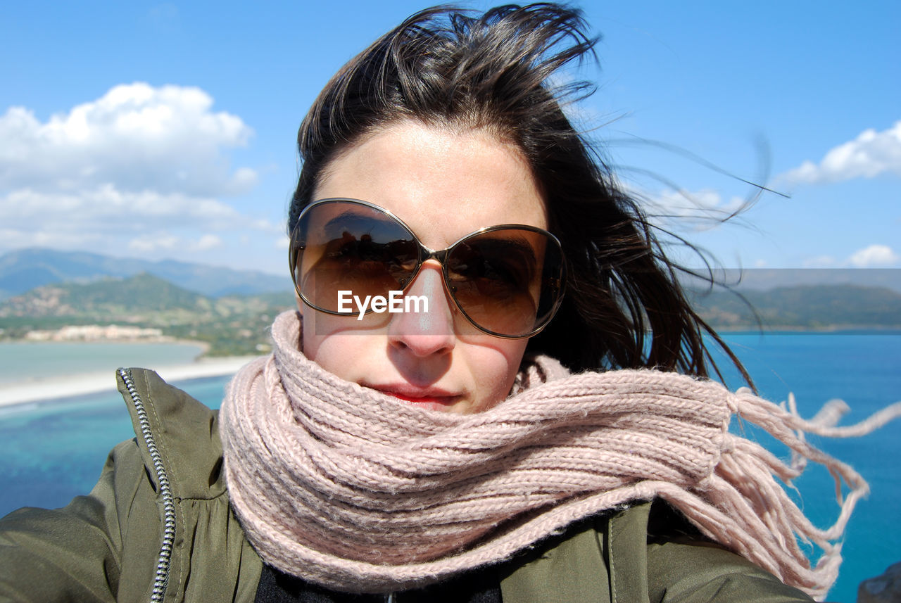 Portrait of young woman wearing sunglasses against sky