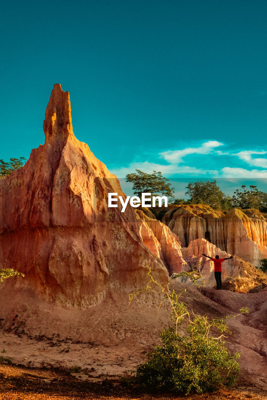 Tourists dwarfed by the rock formations at marafa depression - hell's kitchen at sunset in kenya