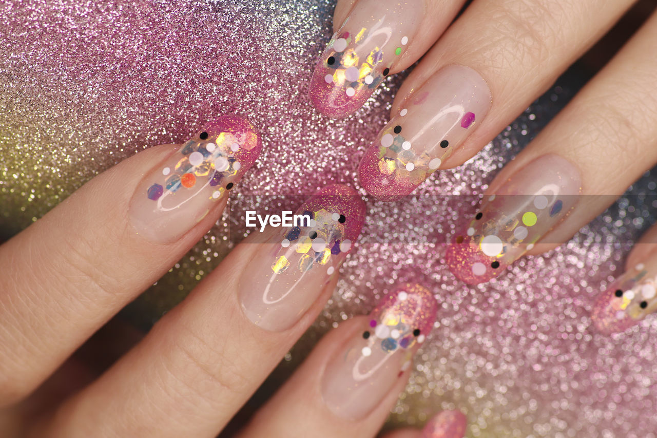 Close-up of woman hand on purple flowers