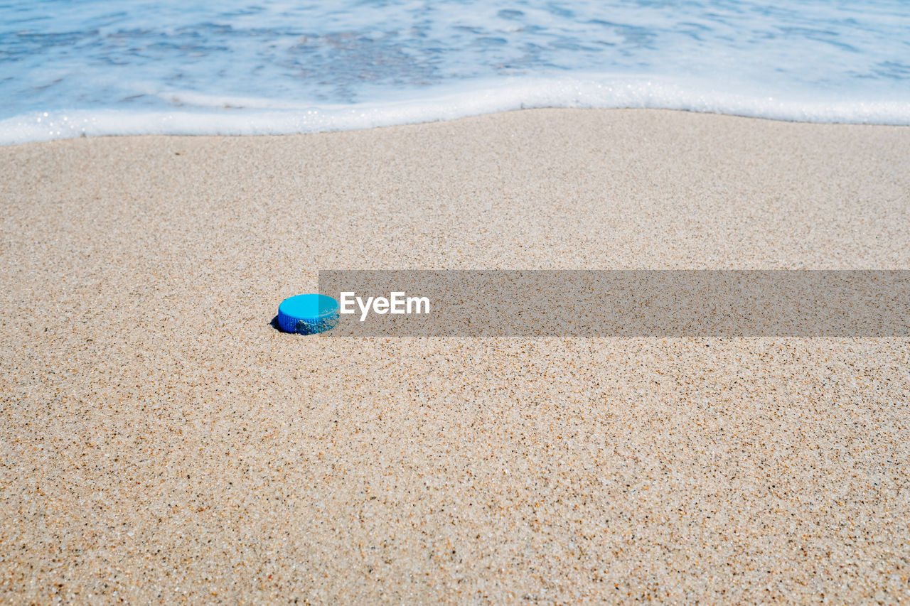 HIGH ANGLE VIEW OF BALL ON SAND