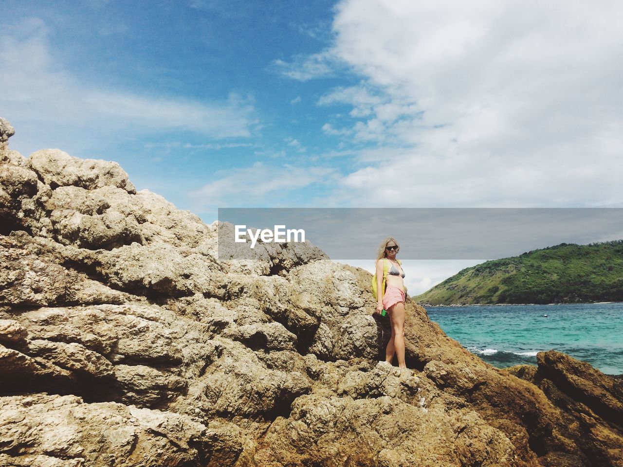 Mid adult woman standing on rocky shore