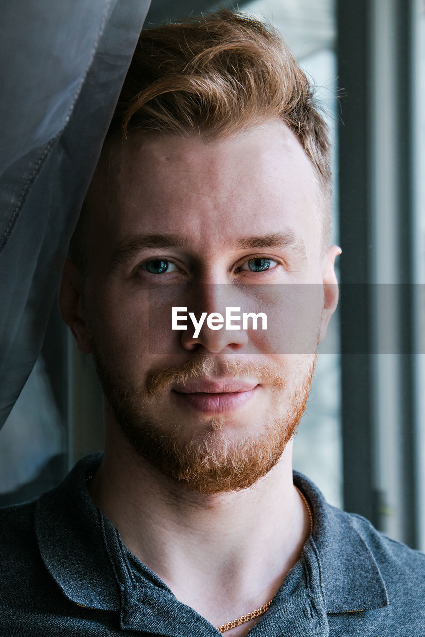 Close-up portrait of smiling mid adult man at home