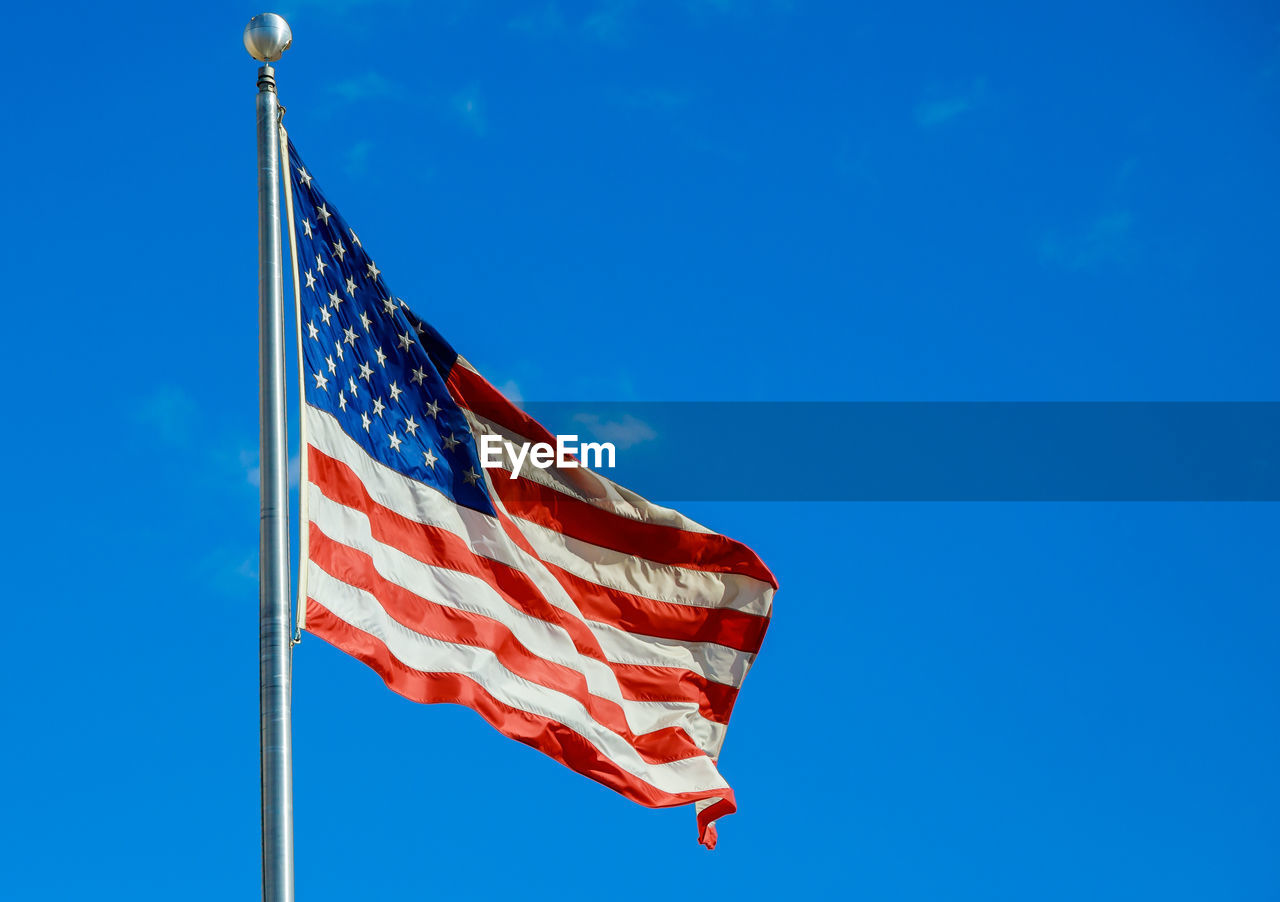 low angle view of flag against clear blue sky