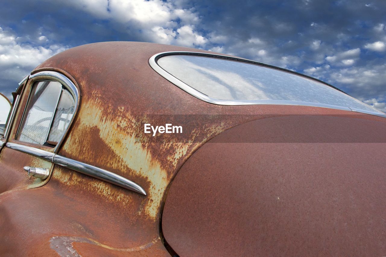 Rusty vintage car against sky
