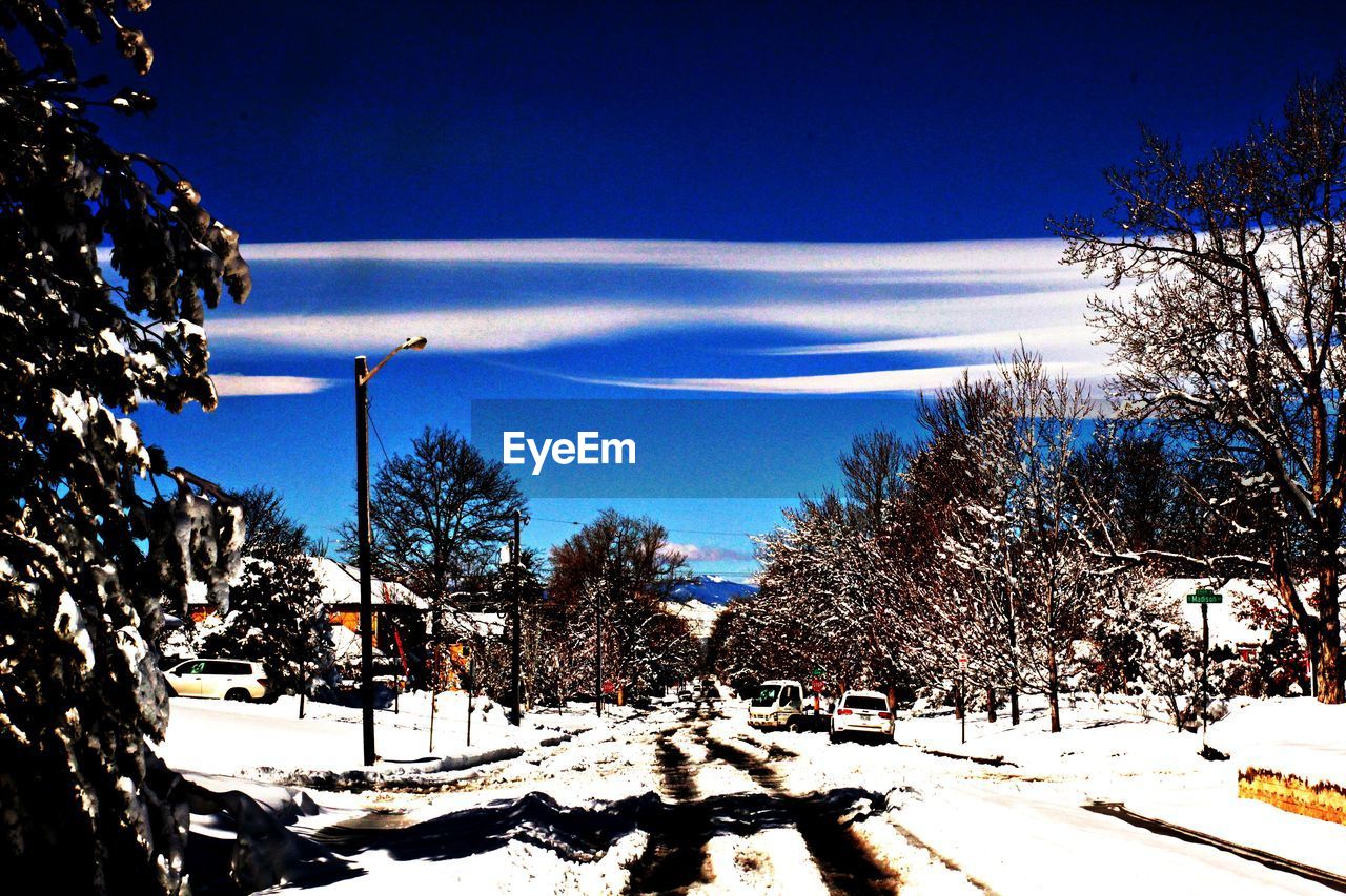 SNOW COVERED LANDSCAPE AGAINST BLUE SKY