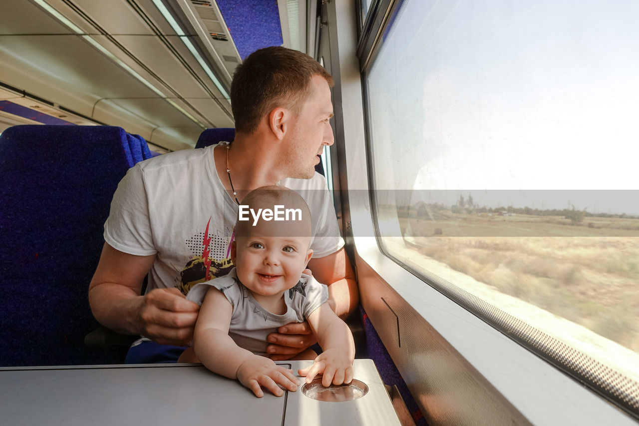 Man father travelling with his little son by train