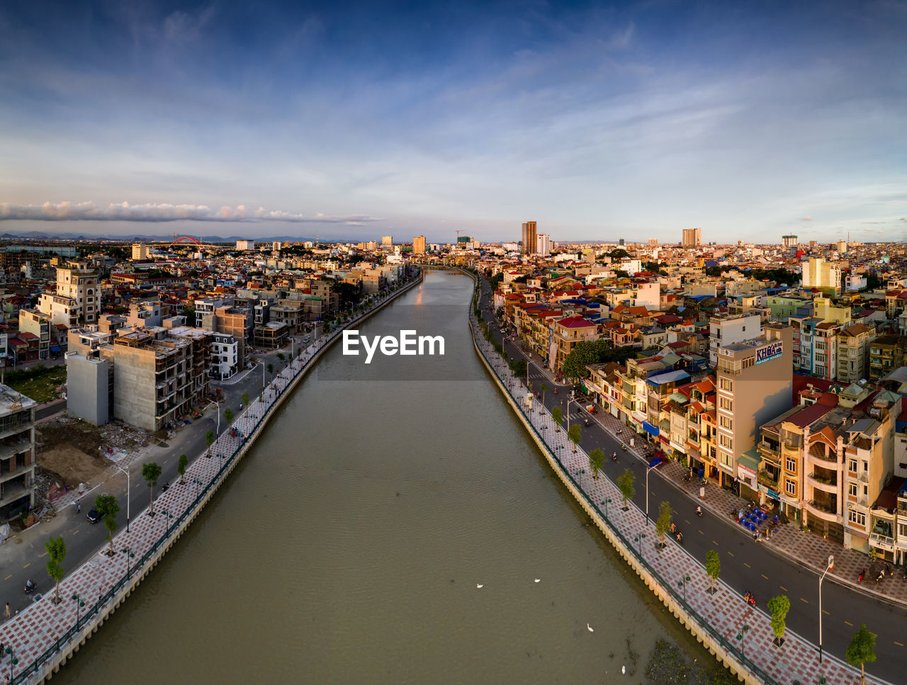 High angle view of river amidst buildings in city against sky