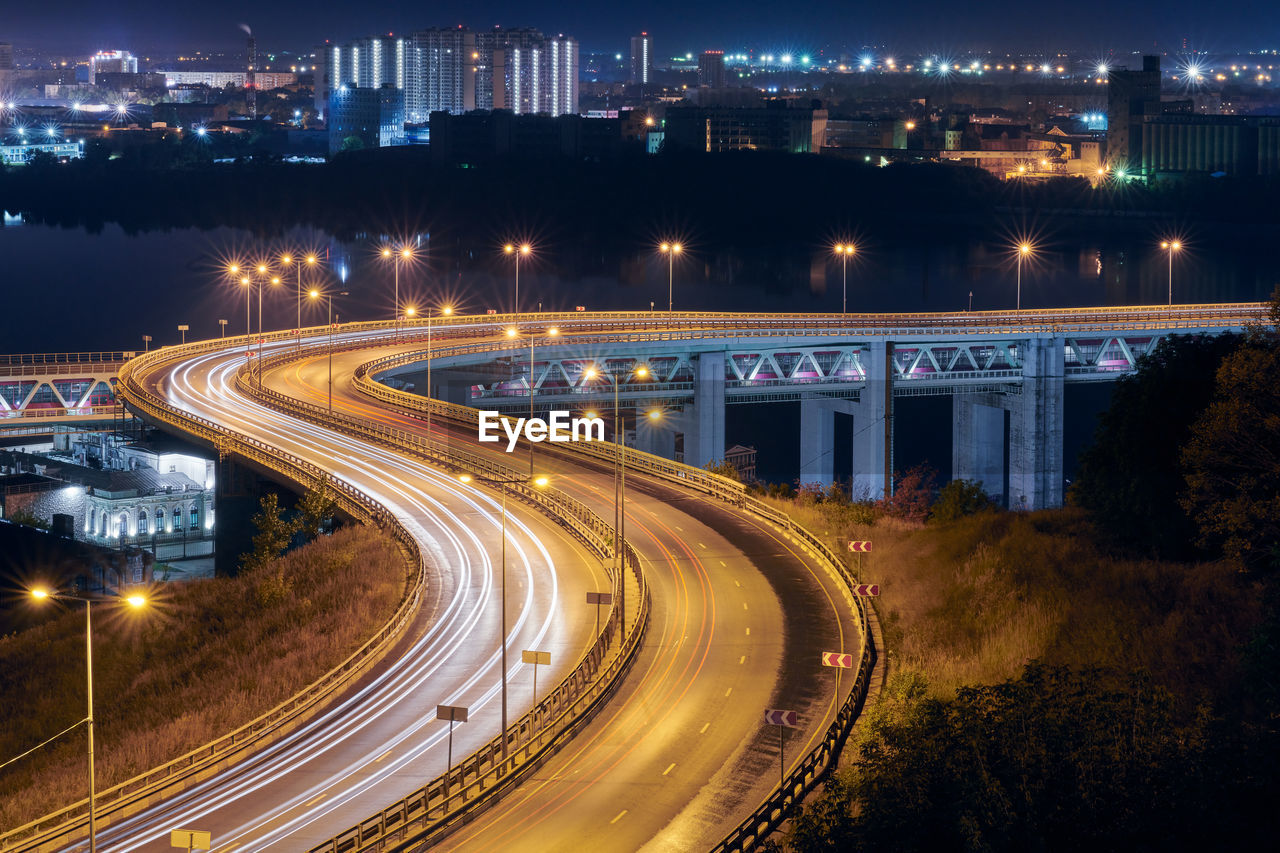 Highway at night lights. fast car light path, trails and streaks on interchange bridge road. night